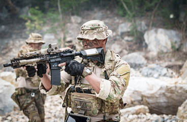 Fototapeta premium Special forces soldier in camouflage aiming a rifle during a tactical operation