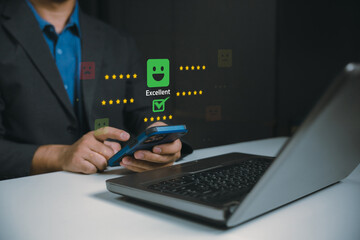 Fototapeta premium A business professional uses a smartphone and laptop to provide an excellent customer satisfaction rating in a digital review system.