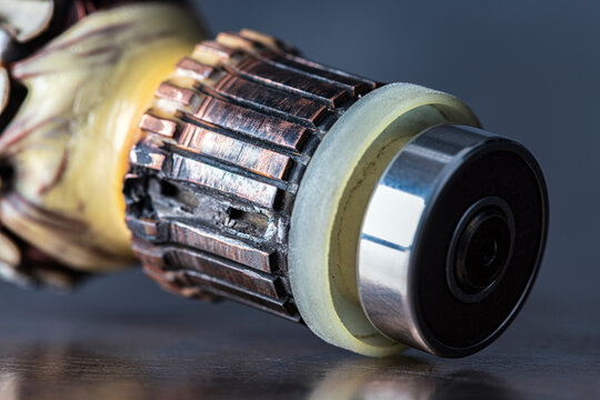 Damaged commutator from a brushed electric motor, burnt contacts, darkened segments, and signs of electrical wear and overheating