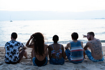 Obraz premium Friends enjoying serene beach sunset.