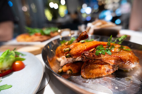 Crispy Roasted Chicken Wings with Herbs Served on Metal Tray in Restaurant Setting