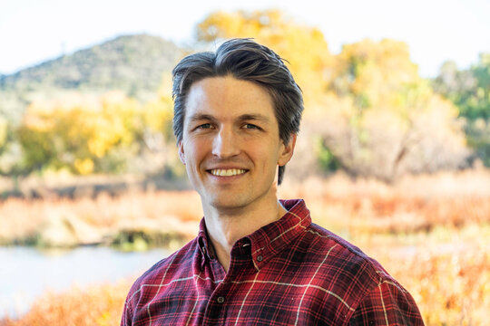 Smiling man outdoors in plaid shirt
