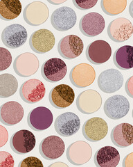 Obraz premium Pattern of colorful eyeshadow pans with matte, shimmer, metallic, crushed powder textures. Minimal cosmetics background, colored swatches of compact powder for makeup. Contemporary cosmetic aesthetic