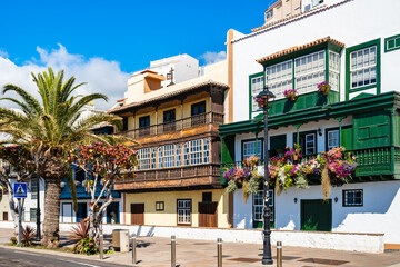 Fototapeta premium Intricately detailed traditional dark green wooden balconies are bursting with vibrant multi-coloured flowers in Santa Cruz town, La Palma, Canary Islands, Spain