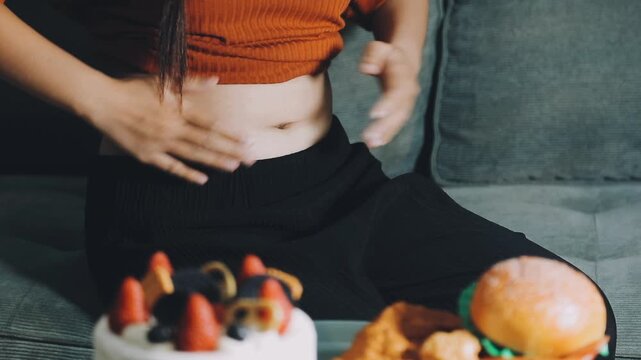 woman's hand holding excessive belly fat, overweight concept