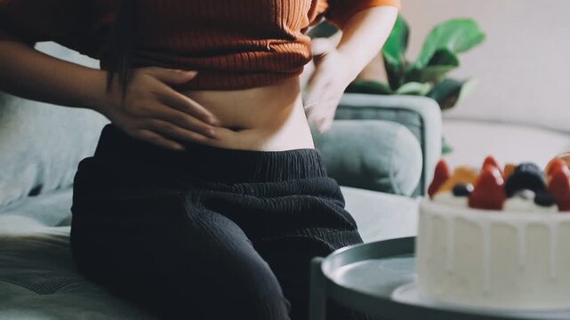 woman's hand holding excessive belly fat, overweight concept