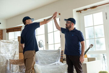 Movers celebrating successful home relocation. © Rawpixel.com