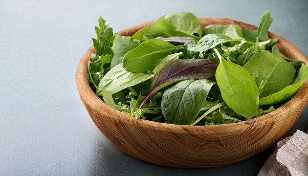 fresh spring mix salad leaves in wooden bowl with spinach arugula and lettuce