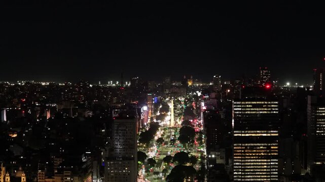 Vista a&eacute;rea nocturna con dron de la ciudad de Buenos Aires sobre la Avenida 9 de Julio y el Obelisco iluminado con tr&aacute;nsito urbano