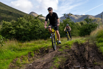 Naklejka premium Cyclists exploring muddy mountain trails.