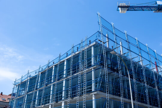 Building construction progress with scaffolding and safety net