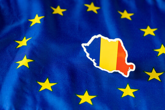 Romania flag cutout in country silhouette shape inside the European Union flag stars. Romania Schengen zone, euro adoption and economic integration concept (Authentic camera photograph)