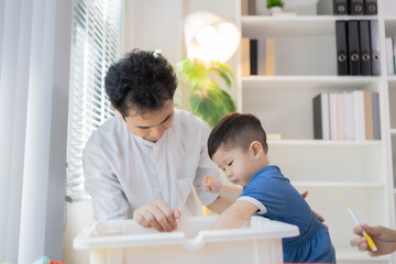 Obraz premium Young family shares joyful moments on floor. Parents smile warmly while playing with child. Child laughs happily in parents' arms. Bright colors and toys fill cozy living room 