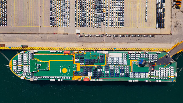 Large car carrier ship docking at a commercial port terminal, transporting and offloading new automobiles, highlighting global logistics and automotive industry supply chain