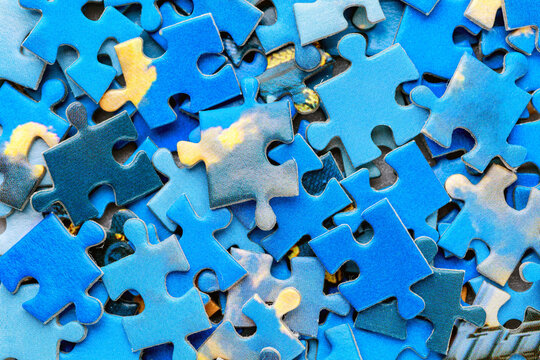 Jigsaw puzzle pieces.Colorful background with small puzzle pieces, messy.Some colored pieces of puzzle as background.Challenge and solution concept. Hobbies and leisure activities
