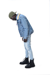Fototapeta premium Portrait of a young man in street clothes from side view looking down on a white background.