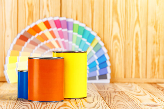 Painter and decorator work table with house project, color swatches, painting roller and paint brushes