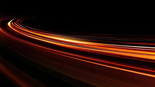 Cars move quickly along the highway, leaving bright trails of light in the dark. The setting shows the motion of vehicles at night and the glow of city lights