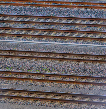 Parallel railway tracks forming geometric transport pattern on gravel ballast.