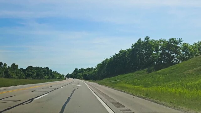 arrows on highway road signaling to merge ahead. travel with bright blue sky on a clear summer day. transportation and infrastructure 