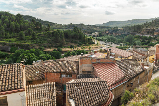Rooftop view of Margalef village surrounded by forested hills and rugged Mediterranean landscape in Priorat region, Catalonia, Spain