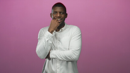 Fototapeta premium Man wearing white buttondown shirt, smiling with hands on hips, slight beard, facing camera in studio; confident approachable.
