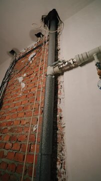 In-wall utility pipes in unfinished masonry wall