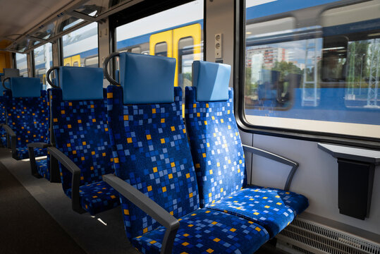 Empty commuter train interior with modern blue passenger seats