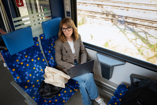 Mature businesswoman working on laptop during train commute