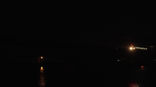 夜の佐賀県唐津市で松浦川の鉄橋を渡るJR筑肥線の列車の光と水面反射の4K動画

