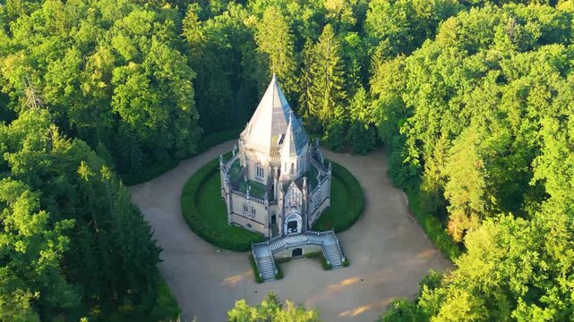 The video showcases the stunning Schwarzenberg tomb located in Domanin, surrounded by lush forests. A serene view highlights its unique architecture and tranquil setting in nature.