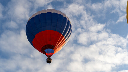 Obraz premium Hot air balloon glides above clouds