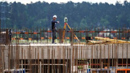 Worker stands atop a construction site © I