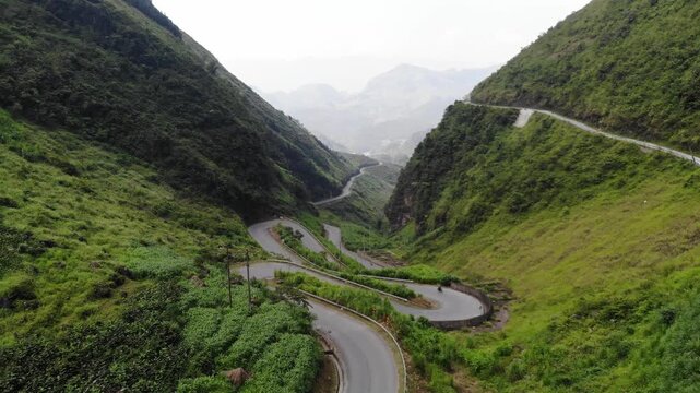 Aerial Drone Flying Over Winding Ha Giang Loop Road Panning Down Between Mountain Ranges, Northern Vietnam