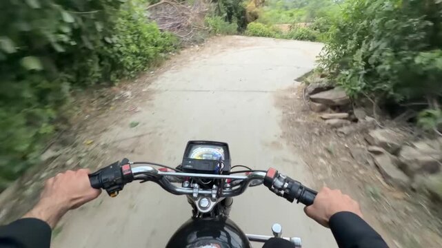 Motorcycle ride view showing dashboard and handlebars on a narrow rural path.