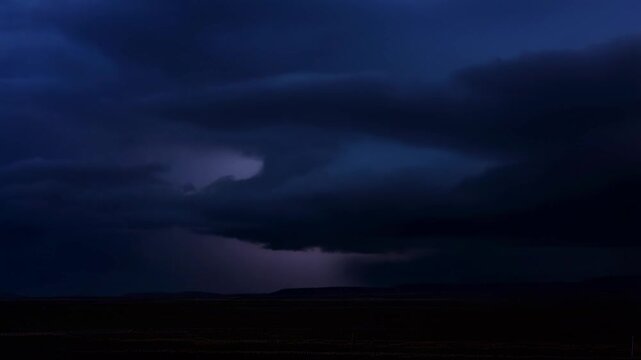 Dramatic lightning storm unfolds over dark landscape with rolling clouds
