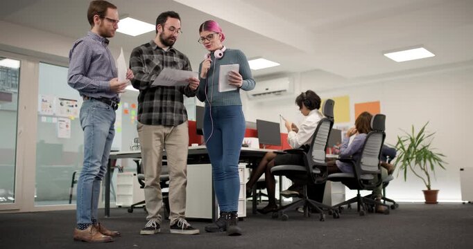 Team members discuss project details while working in a modern office space during the afternoon hours with a focus on collaboration and planning