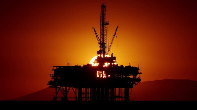 Time lapse of the sun setting behind an offshore oil platform off the coast of California