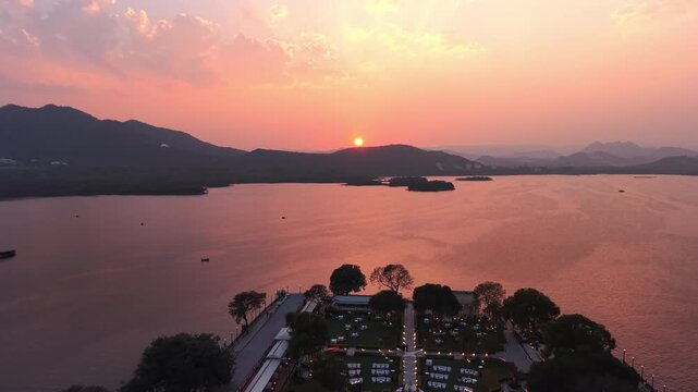 Sunset Drone View of Jag Mandir Island Palace Udaipur on Lake Pichola Featuring Golden Hour Sky, Royal Architecture, and Scenic Rajasthan Heritage Landscape