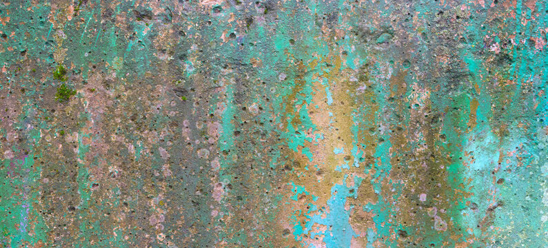 Weathered wall texture shows faded paint layers. Peeling blue and green paint patches are visible. Cracks and discoloration create rustic appearance. Ideal for design backgrounds or vintage themes