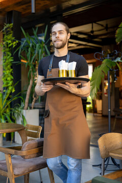 Cheerful server holding tray in cafe