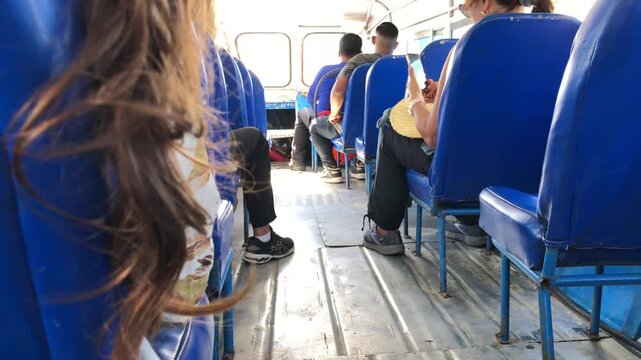 Daytime passenger van interior with blue vinyl seats and central aisle