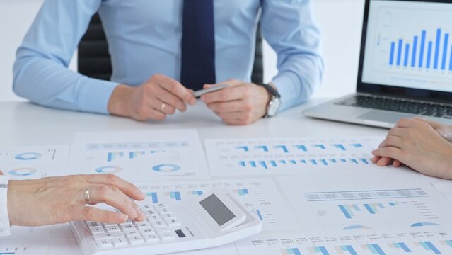 Accouters analyzing financial data using charts, graphs, and reports during an office meeting, collaborating on strategy. Business people concept