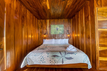 Obraz premium Cozy wooden bedroom with hummingbird artwork and warm lighting