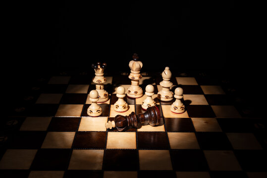 Chess king lying defeated among standing pieces on a board, symbolizing strategy, leadership, victory, failure, decision‑making, competition and business conflict.