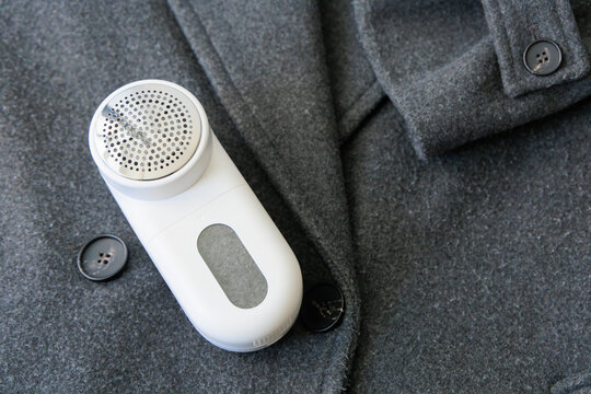 Lint remover placed on a wool coat pocket during a clothing maintenance routine at home in autumn season