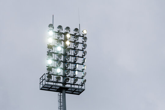 Arena floodlight mast with turned on lamps