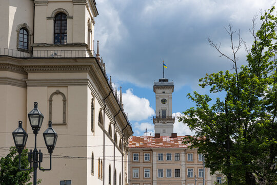 Lviv city hall ratusha tower with ukrainian flag behind historic buildings