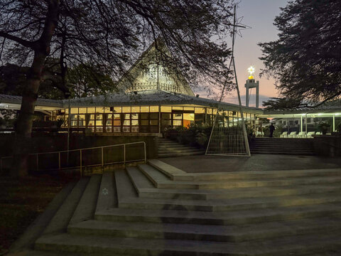 Wider view of The First Church of Chiang Mai illuminated at twilight
