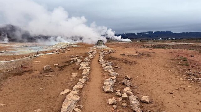 Volcanic landscape with geothermal activity in the Hverir area, Iceland. Steaming fumaroles and boiling mud pots under a cloudy sky